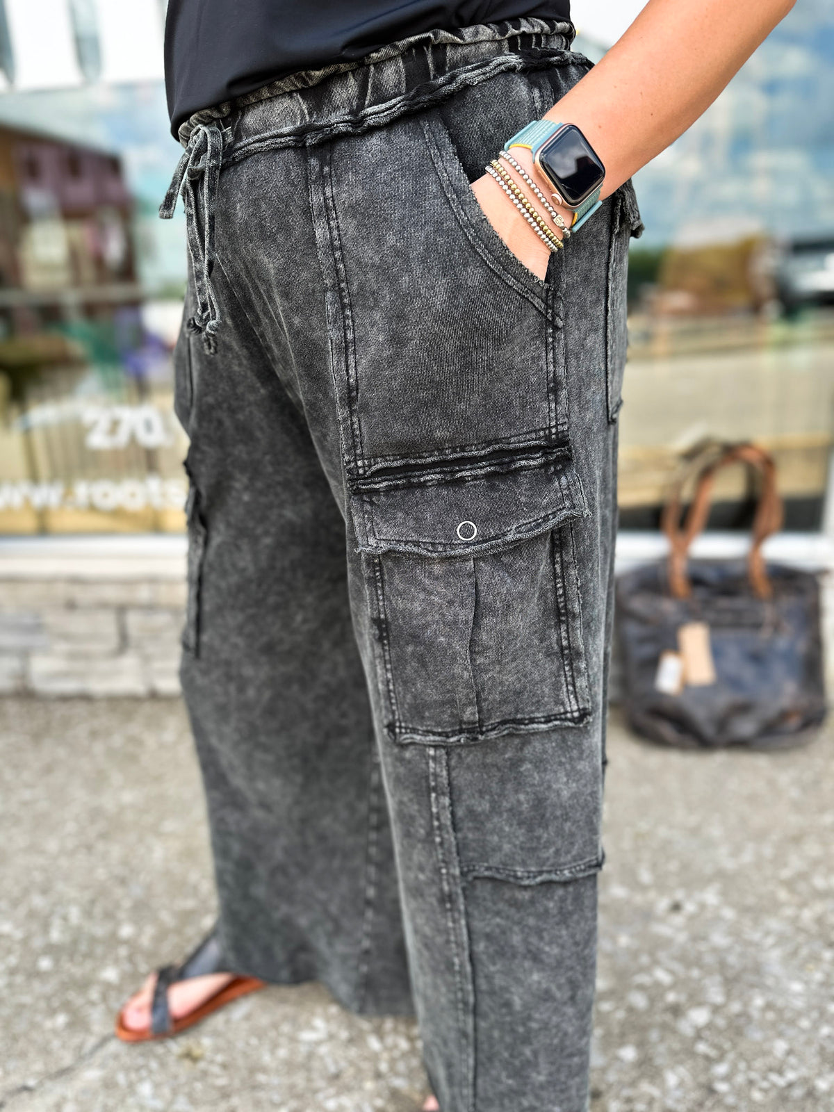 Person wearing black cargo pants with a blurred background