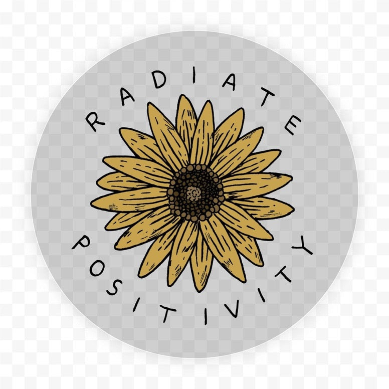 A circular graphic design featuring a hand-drawn yellow sunflower with a dark brown center, surrounded by the words 'RADIATE POSITIVITY' in black uppercase letters on a light gray background. The image is shown on a transparent checkerboard background.