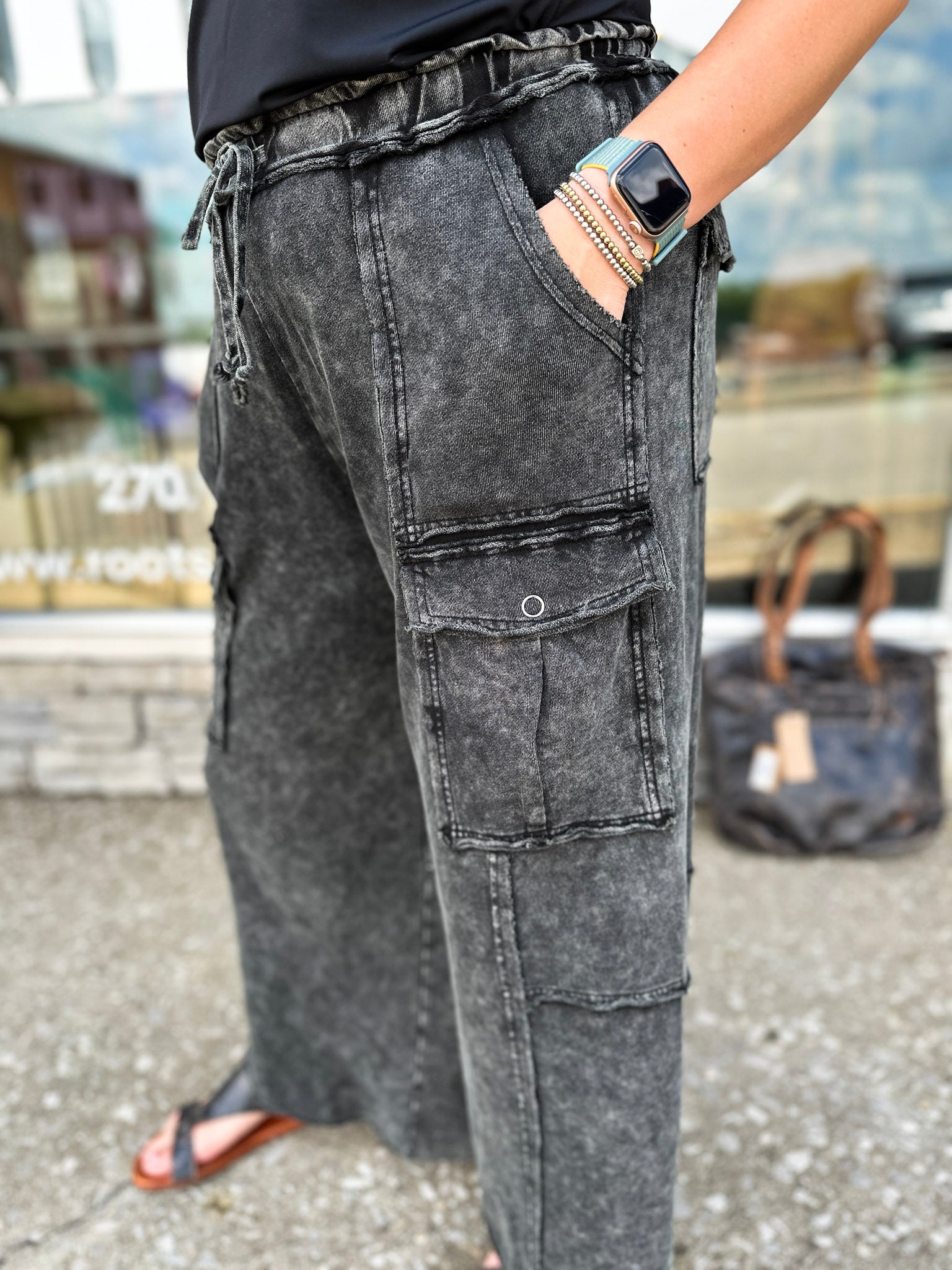 Person wearing black cargo pants with a blurred background