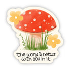 Sticker with a red mushroom, flowers, and text 'the world is better with you in it' on a white background