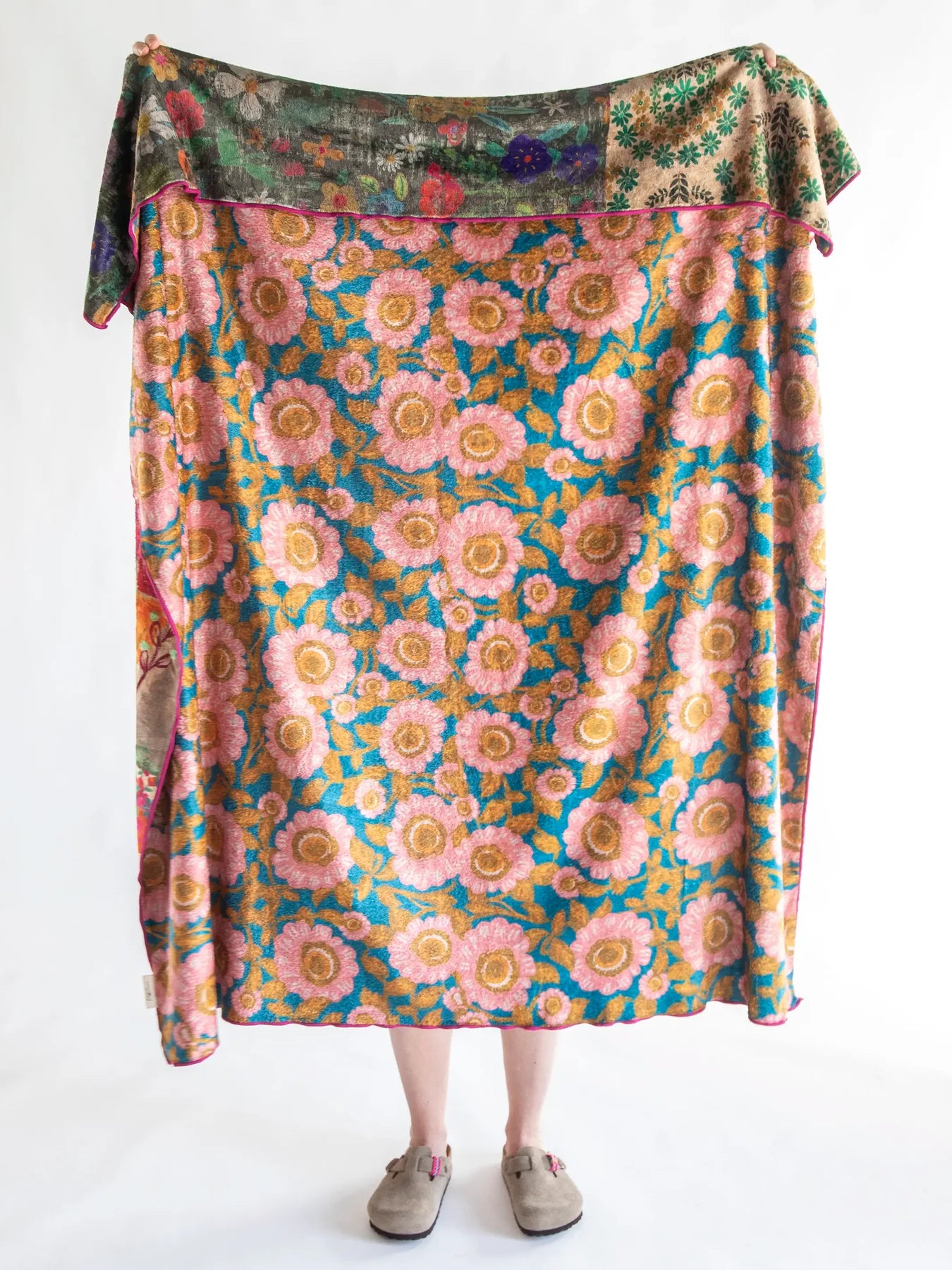 Person wearing a colorful floral skirt with a patterned top on a white background