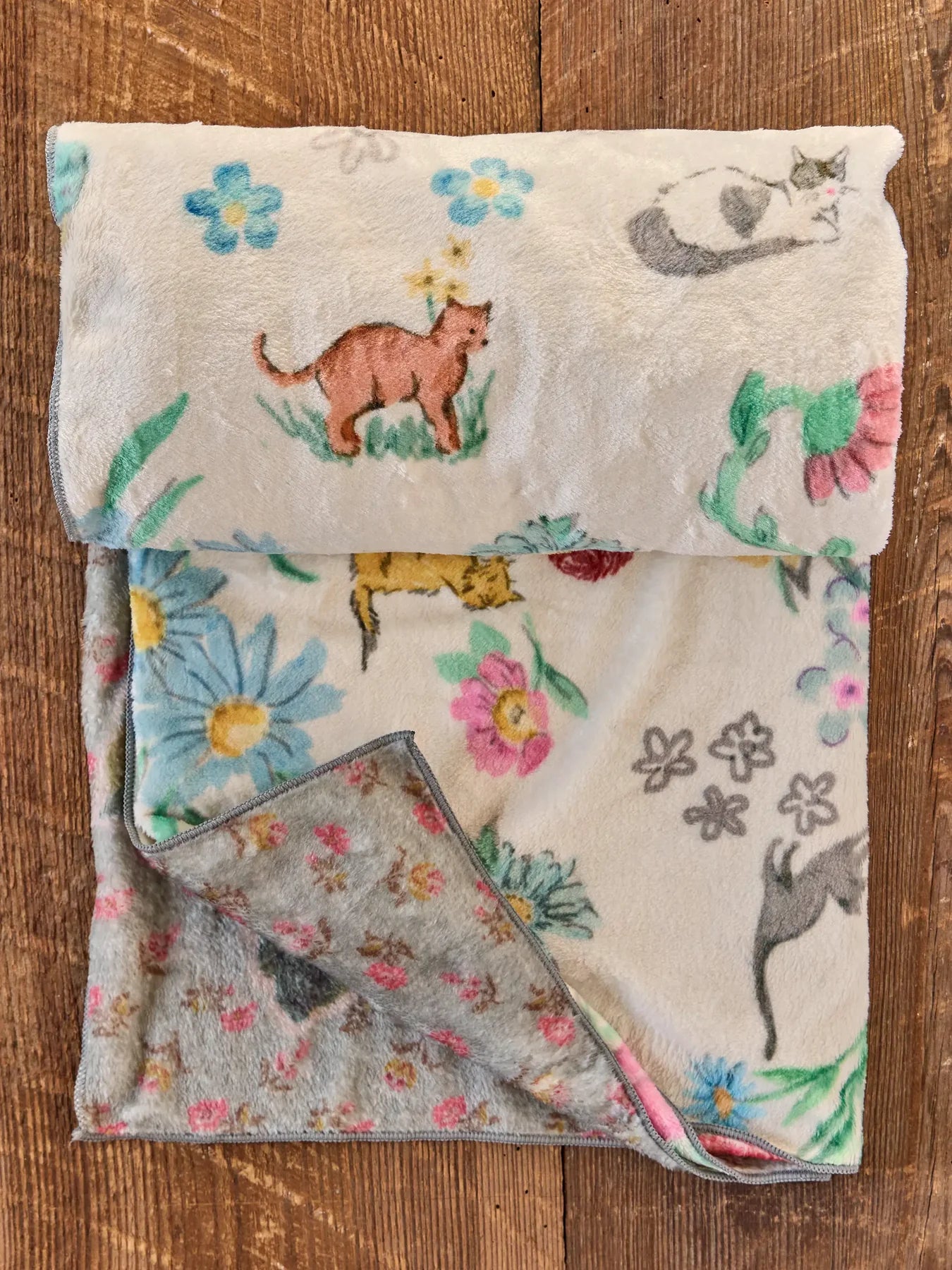 BLANKET WITH KITTENS AND FLOWERS ON WOODEN FLOOR