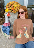 Brown shirt with 2 ducks wearing bandanas 

