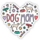 A heart-shaped die-cut sticker featuring the words 'DOG MOM' in large pink and lavender letters, surrounded by cute dog-themed doodles including paw prints, bones, bowls, flowers, and two dog silhouettes on a white background.