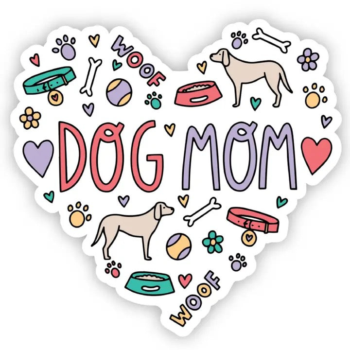 A heart-shaped die-cut sticker featuring the words 'DOG MOM' in large pink and lavender letters, surrounded by cute dog-themed doodles including paw prints, bones, bowls, flowers, and two dog silhouettes on a white background.