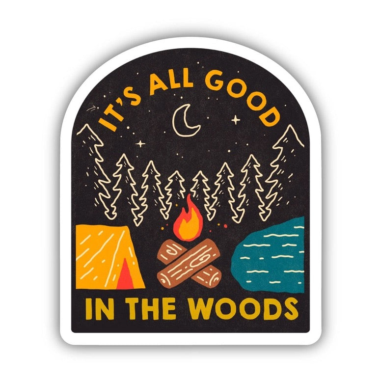 An arched sticker featuring a camping scene with the text 'IT'S ALL GOOD IN THE WOODS'. The design shows pine trees, a crescent moon, stars, a campfire, a tent, logs, and a body of water on a dark background with a white border.