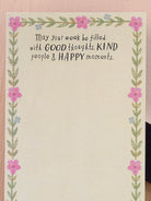 NOTE PAD WITH WORDS ON WOOD BACKGROUND