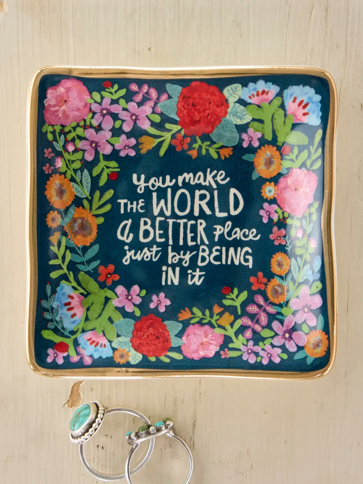 TRINKET DISH WITH FLOWERS AND YOU MAKE THE WORLD A BETTER PLACE JUST BEING IN IT WITH 2 RINGS ON WOOD BACKGROUND