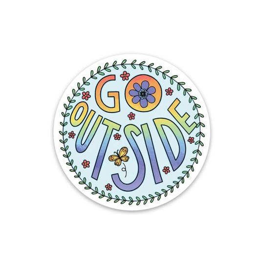 A round sticker featuring the phrase 'GO OUTSIDE' in colorful retro lettering, surrounded by a leafy border, flowers, and a butterfly on a white background.